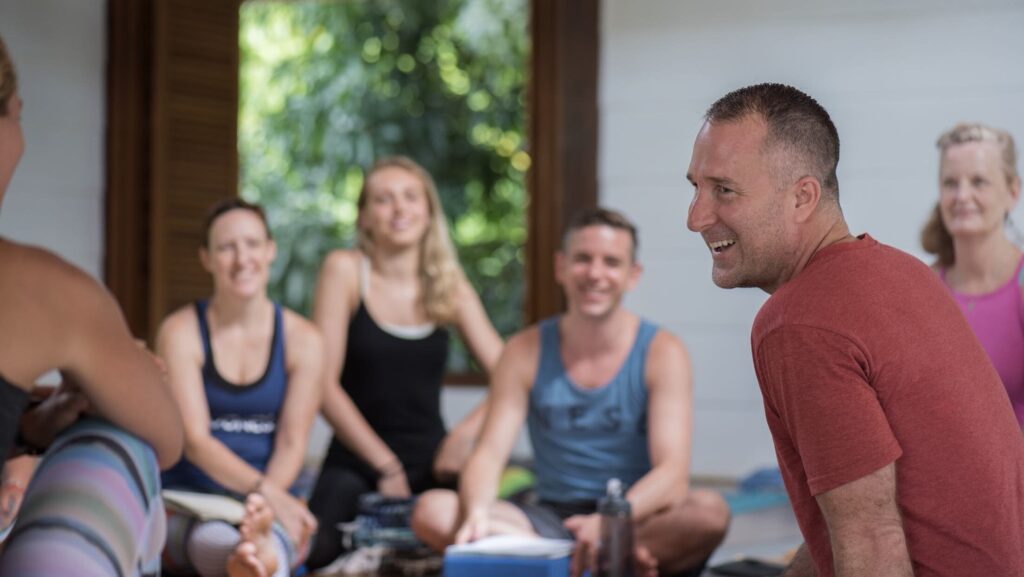 Yogi Aaron teaching a group of students and smiling