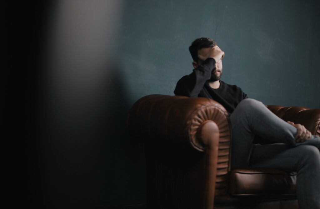 Man sitting and holding his head like he is stressed