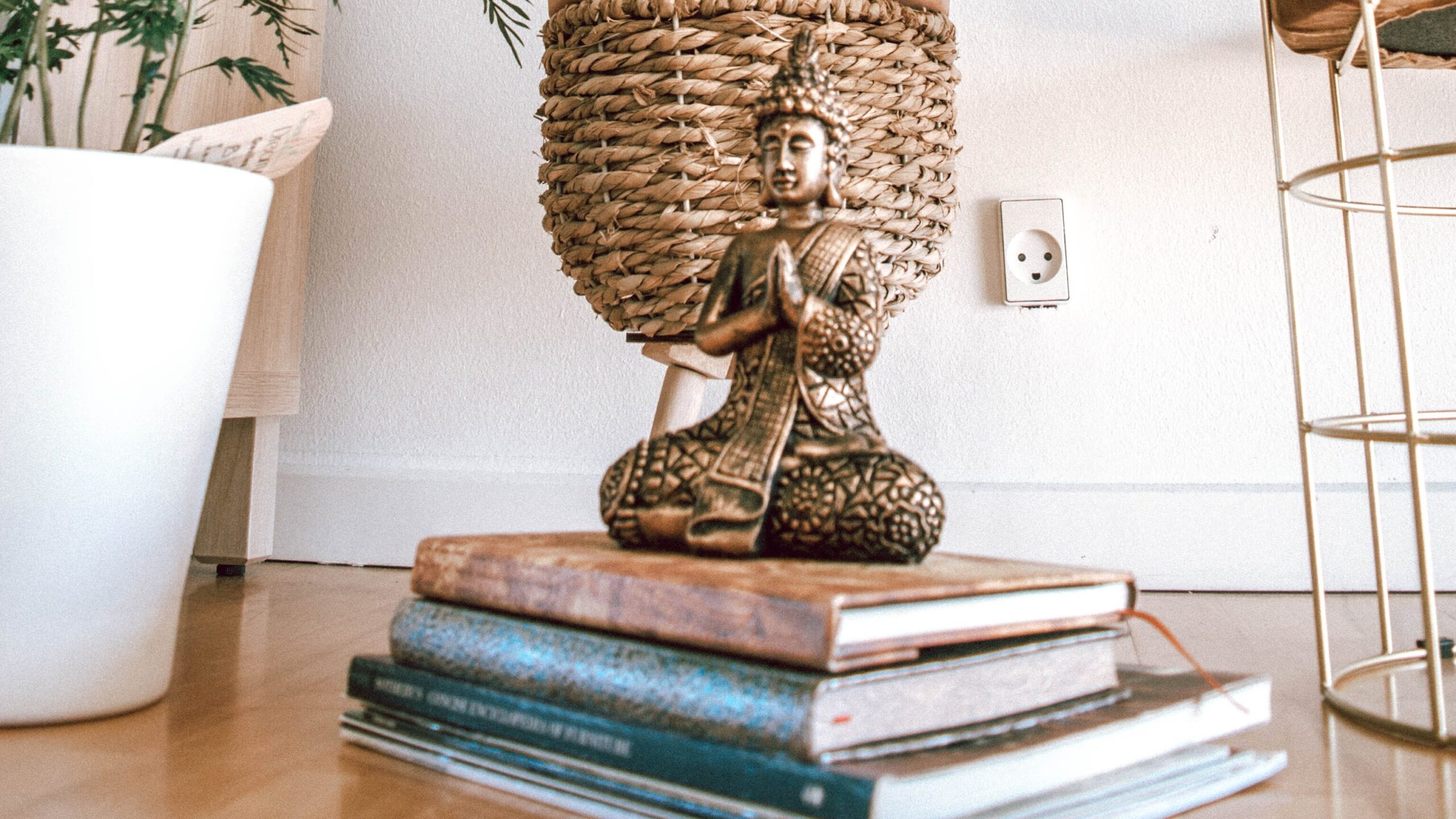 Yoga Books stacked on floor by statue and plants