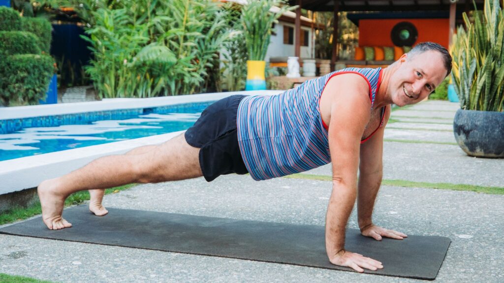 Yogi Aaron Doing Plank Yoga Pose By the Blue Osa Pool