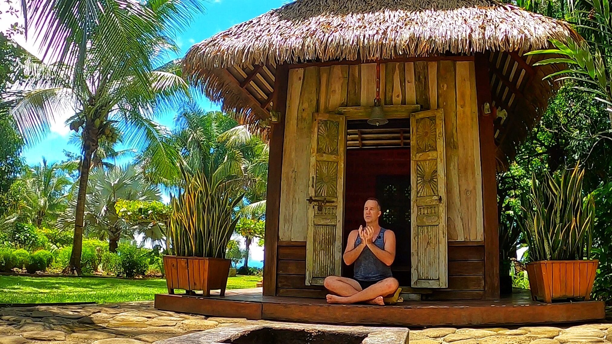 Yogi Aaron meditating in front of the Blue Osa Yoga Retreat Meditation Shala