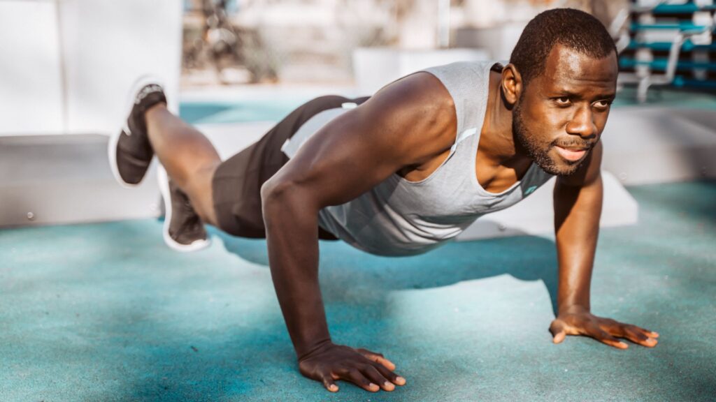 Black Man doing chaturanga or a low push-up yoga pose.