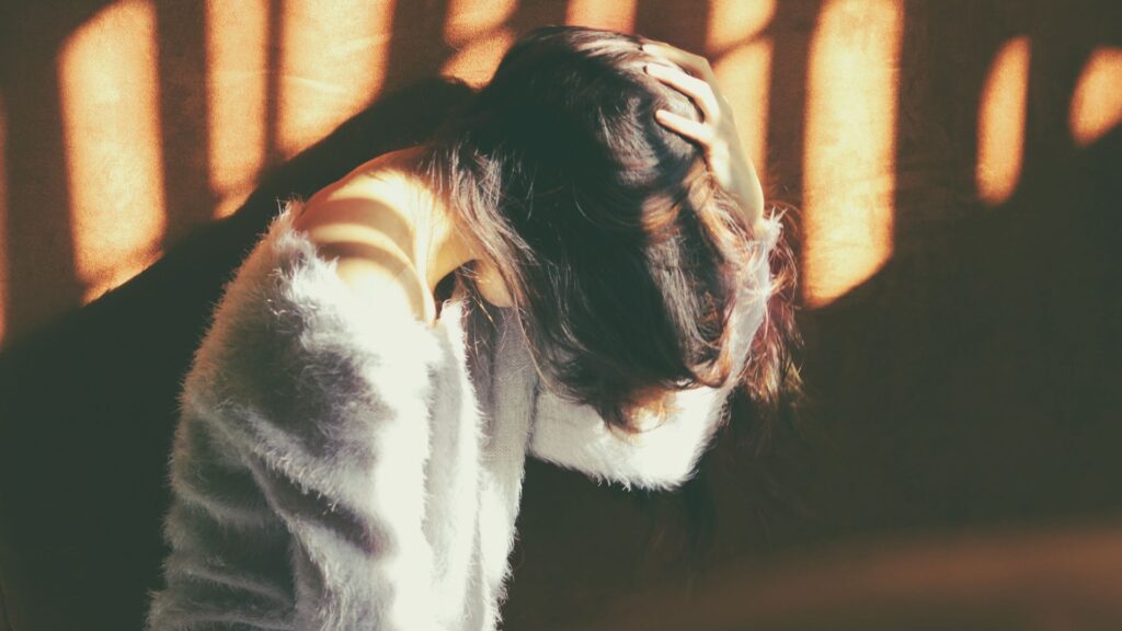 Women holding her head slouching forward in neck pain