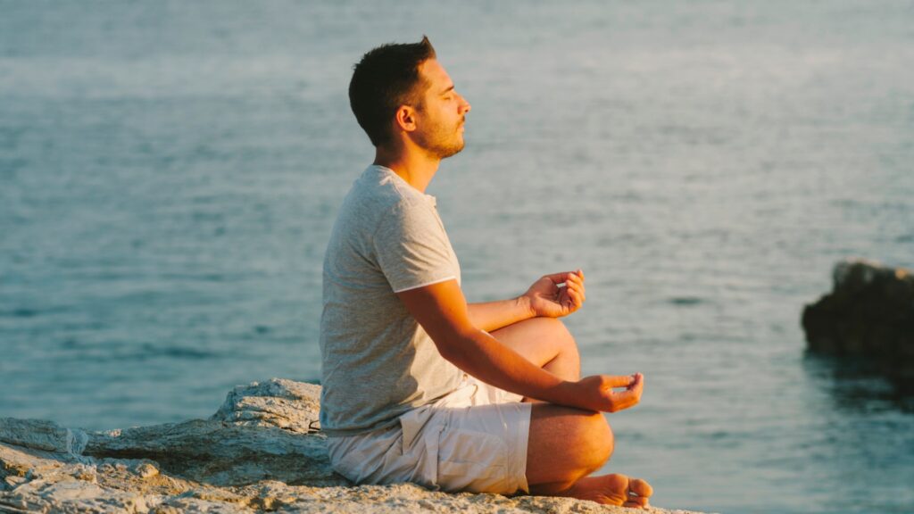Man meditating by the ocean