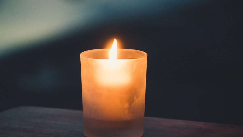 A candle burning at night on a table
