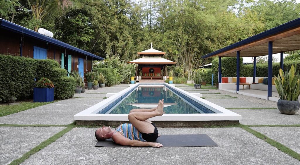 man hugging knees to chest yoga pose