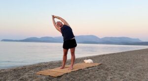 yoga for energy with yogi aaron greece beach side bend pose