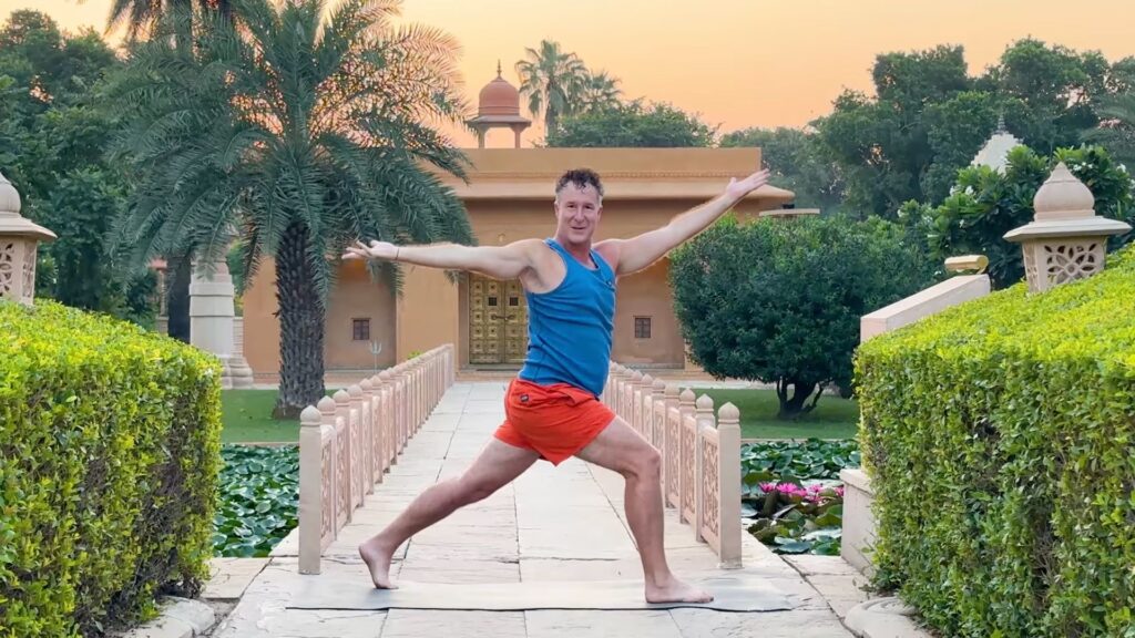 Yogi Aaron doing a Warrior Twisting Pose in front of the Shiva Temple in India
